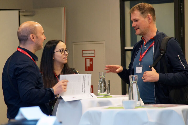 3 participants chatting and drinking coffee.