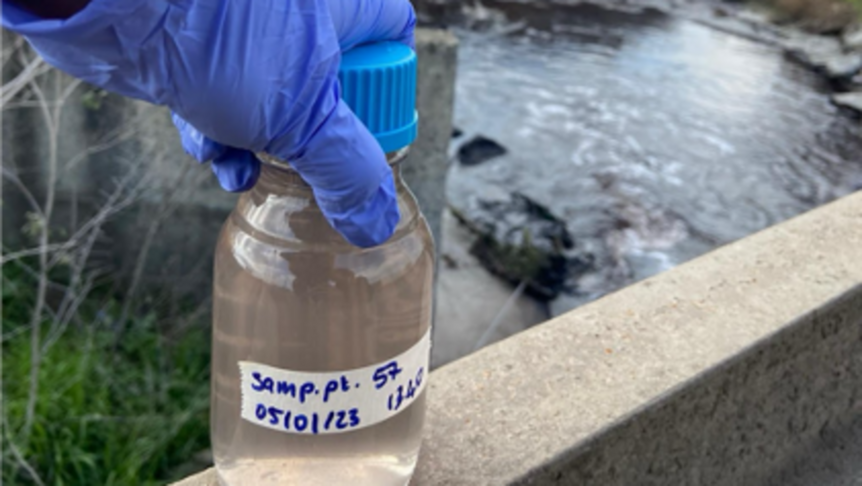 Ein Wassersample aus einem Fluss, abgefüllt in eine Flasche.