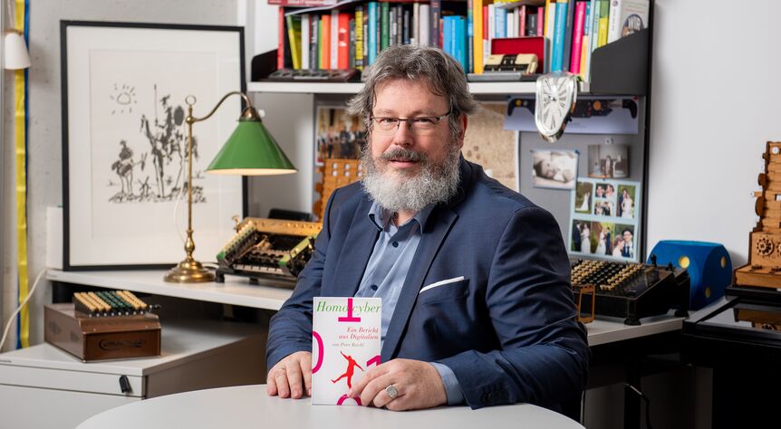 Peter Reichl zeigt sein Buch "Homo Cyber"