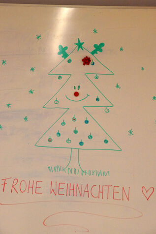 Ein gezeichneter Weihnachtsbaum auf einem Whiteboard des Seminarraums.