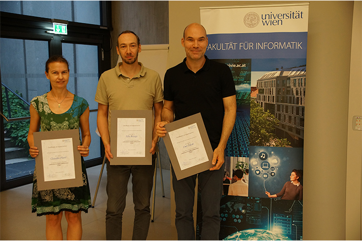 Claudia Plant, Nils Kriege und Uwe Zdun präsentieren im Hörsaal 1 ihre Urkunden.